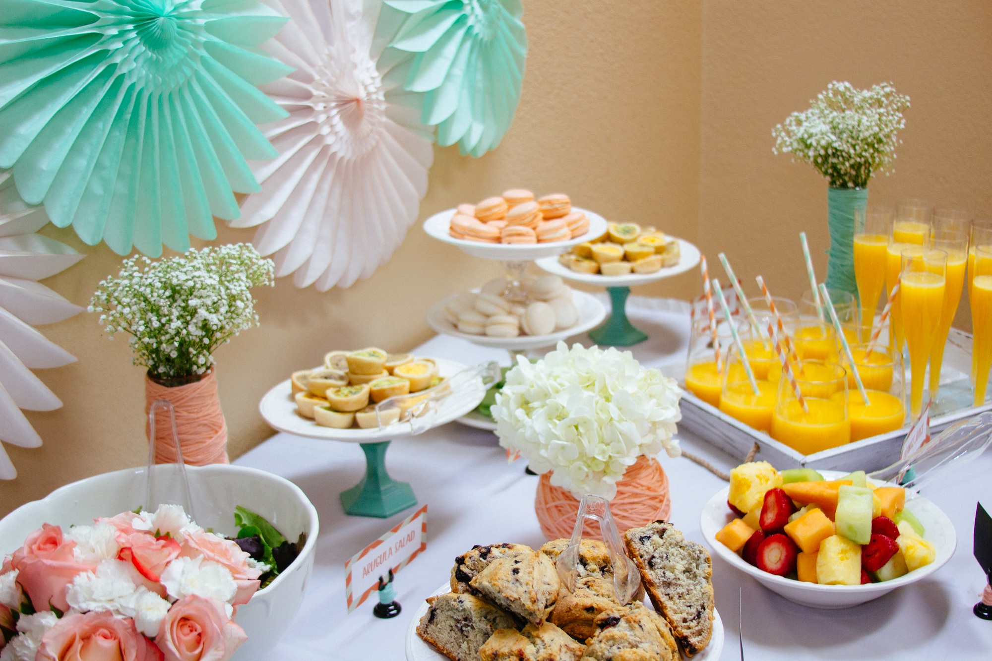Food table with mimosas, macaroons, scones at baby shower